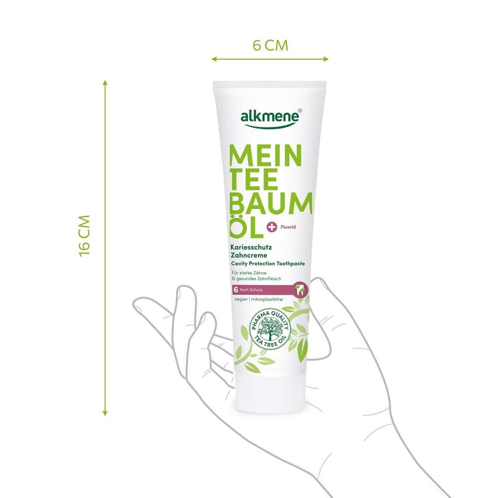Zahncreme-Tube in Hand. Maße: 16 cm hoch, 6 cm breit. Aufschrift: alkmene Mein Teebaumöl + Fluorid.