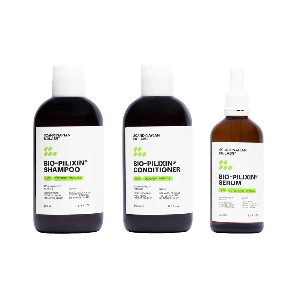 Drei Flaschen mit weißen Etiketten. Shampoo, Conditioner und Serum. Schwarze Flaschen mit weißen Deckeln. Produktnamen sichtbar.