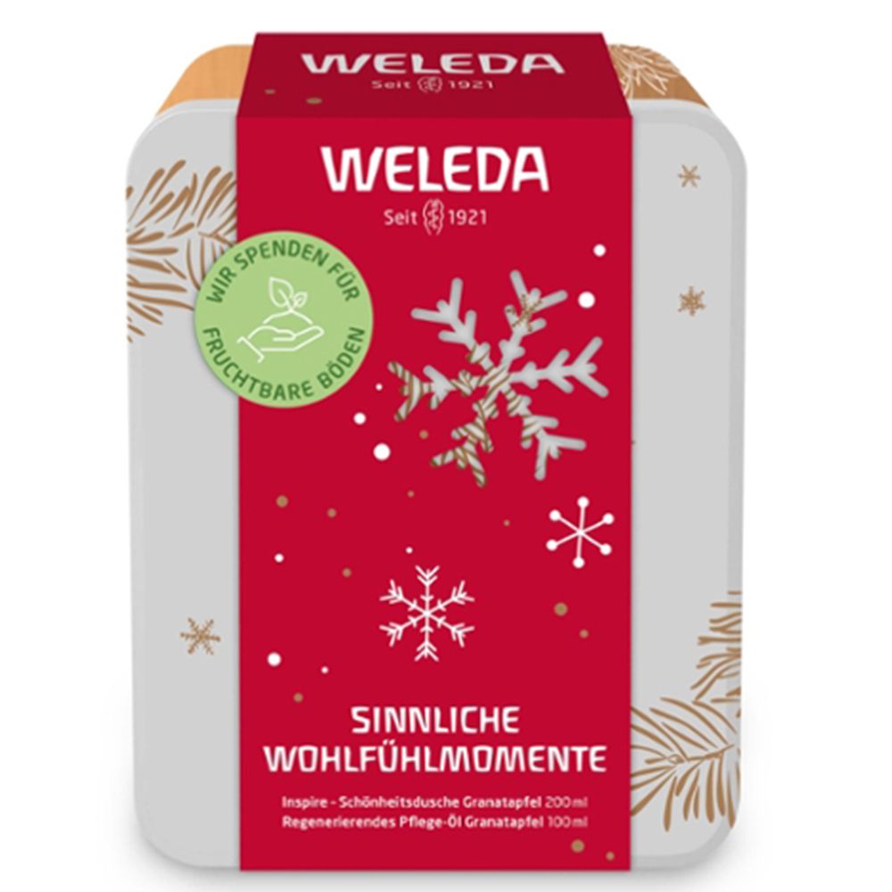 Geschenkset mit roter Banderole. Aufschrift: WELEDA, Sinnliche Wohlfühlmomente. Schneeflocken- und Tannenzweig-Dekor.