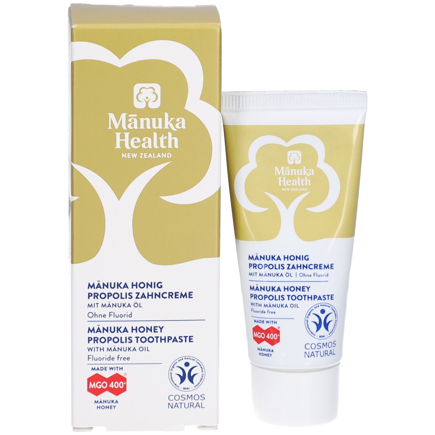 Zahncreme-Tube und Kartonverpackung. Beide zeigen Produktnamen, Logos und Zertifizierungen. Enthält Manuka Honig, Propolis und Öl.