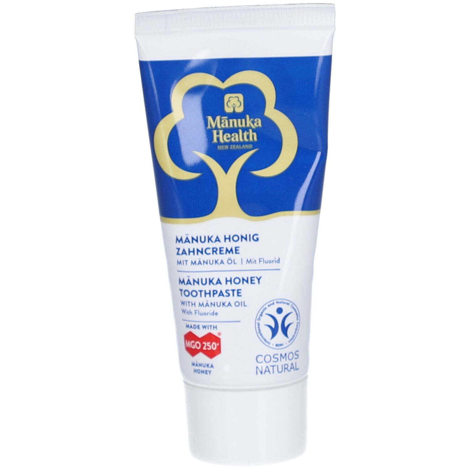 Zahncreme-Tube mit blau-weißem Design. Logo und Schriftzug. Enthält Manuka-Honig und Fluorid. COSMOS NATURAL-Zertifizierung.