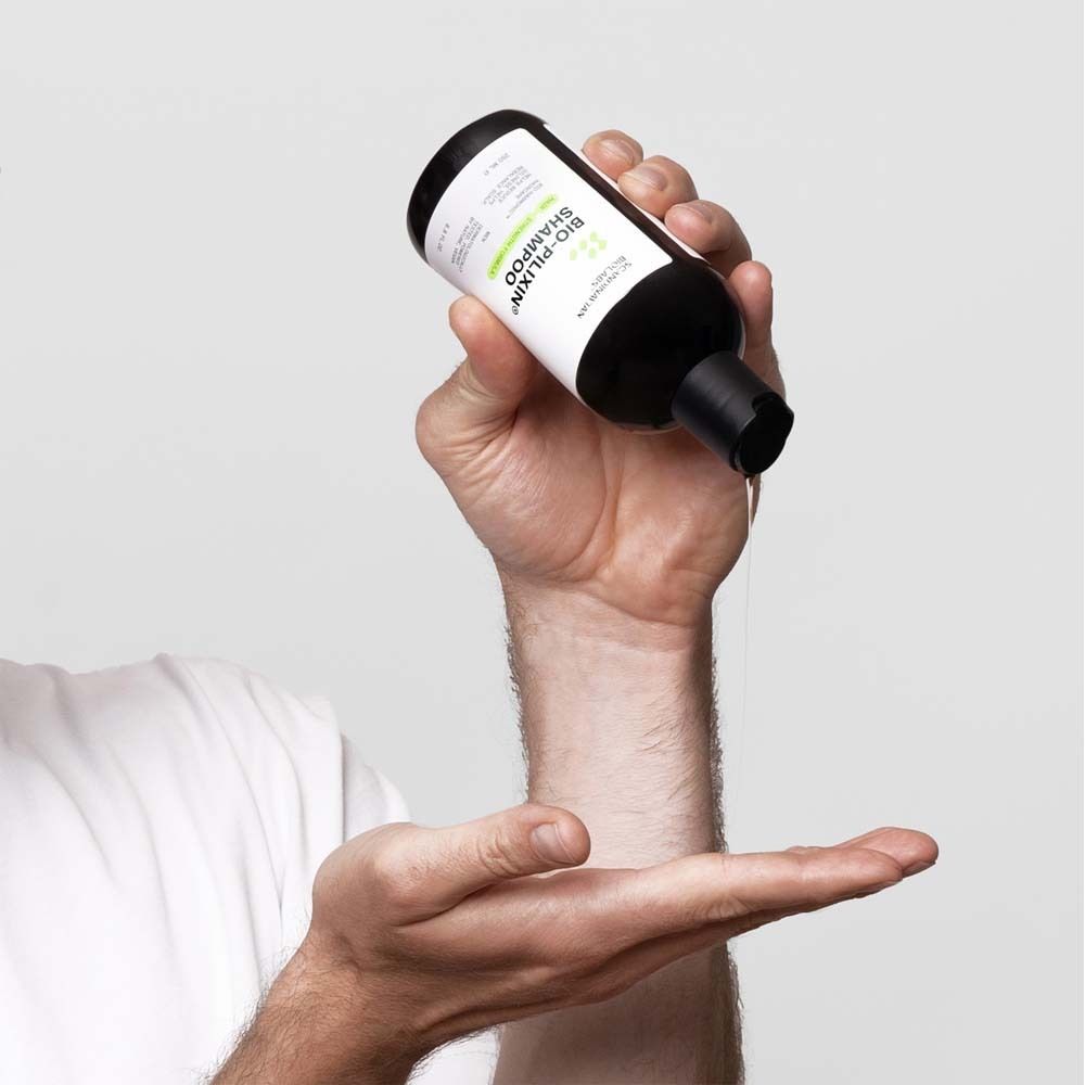 Person hält eine Shampoo-Flasche. Aufschrift: Bio-Pilixin Shampoo.