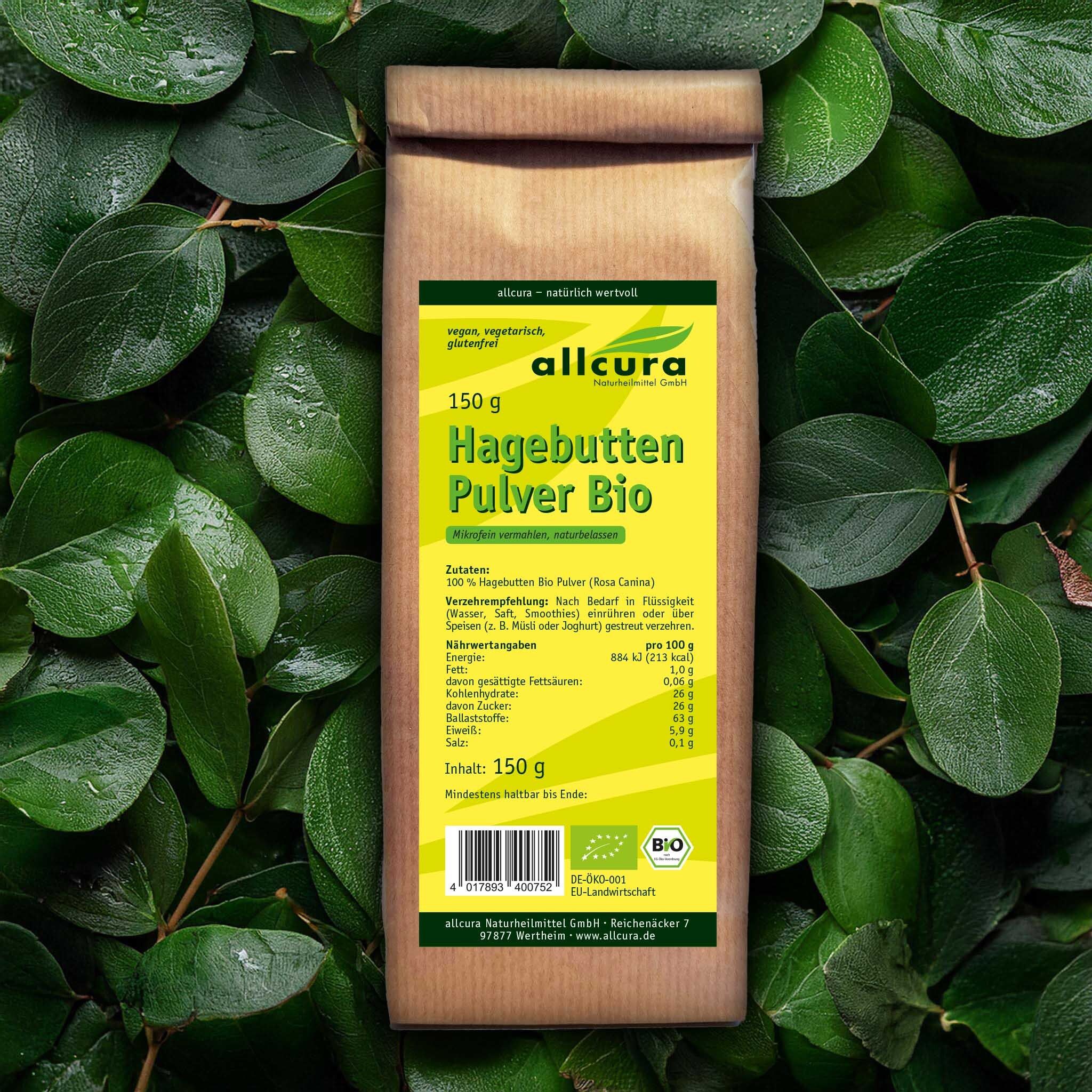 Braune Papiertüte mit grünem Etikett vor grünem Blattwerk. Aufschrift: allcura Hagebutten Pulver Bio, 150g. Bio-Siegel.