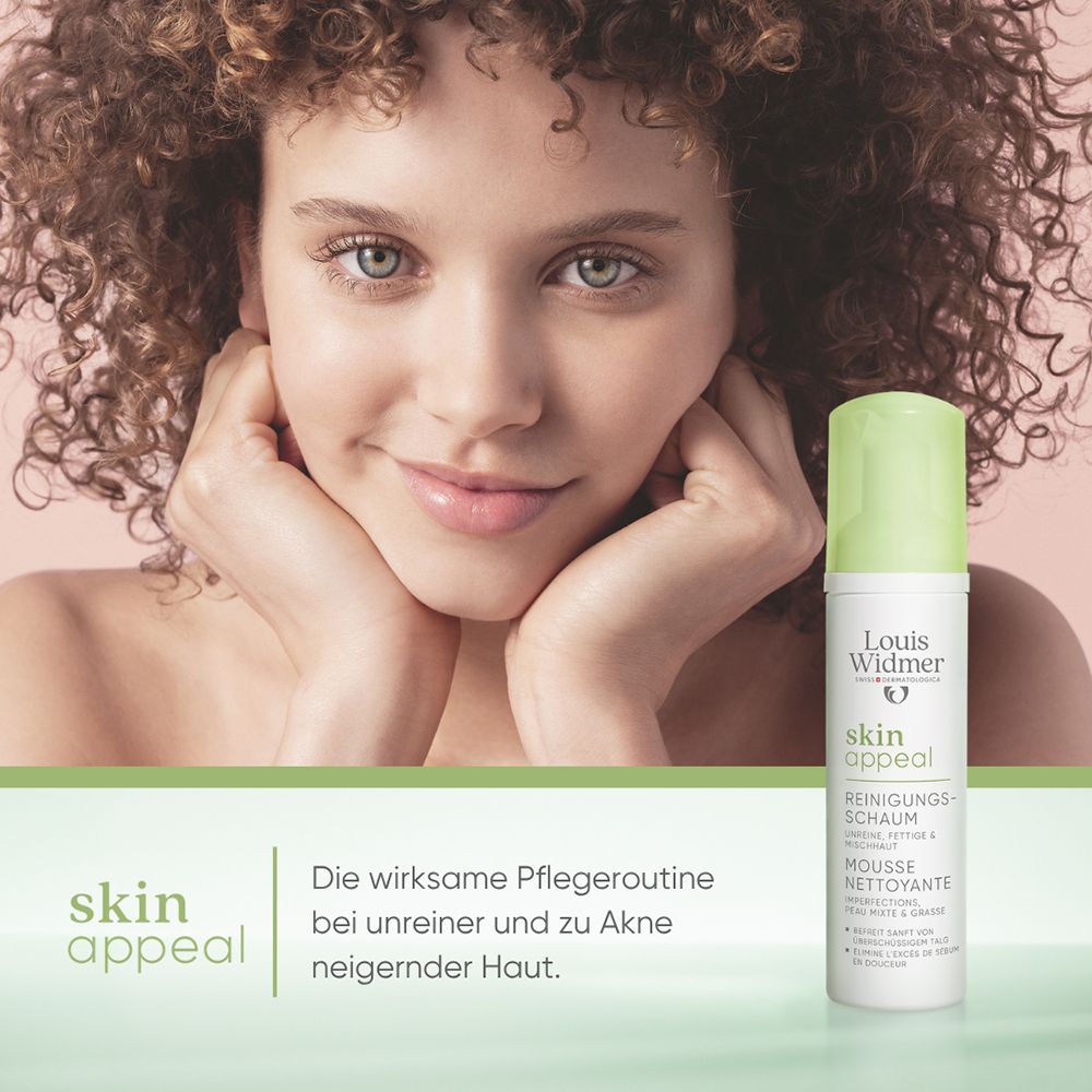 Frau mit lockigem Haar lächelt, neben ihr steht eine Flasche Louis Widmer skinappeal Reinigungsschaum.