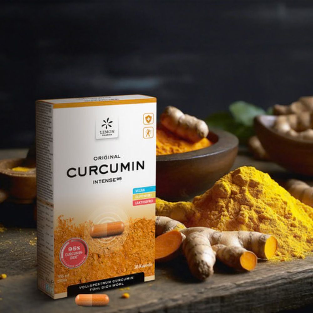 Karton mit Kapseln, Kurkumawurzeln und Pulver. Aufschrift: Original Curcumin Intense95.