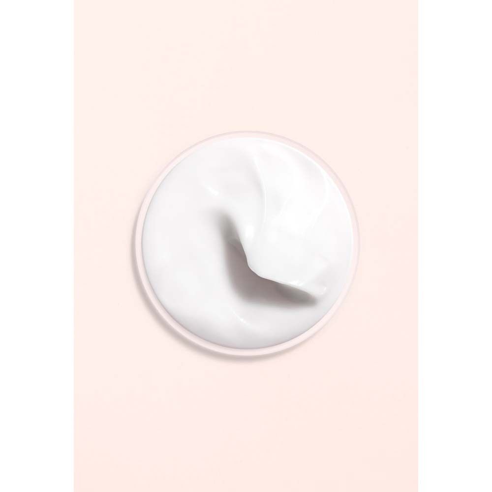 Nahaufnahme einer weißen Creme. Runde Form, glatte Oberfläche. Auf rosa Hintergrund.