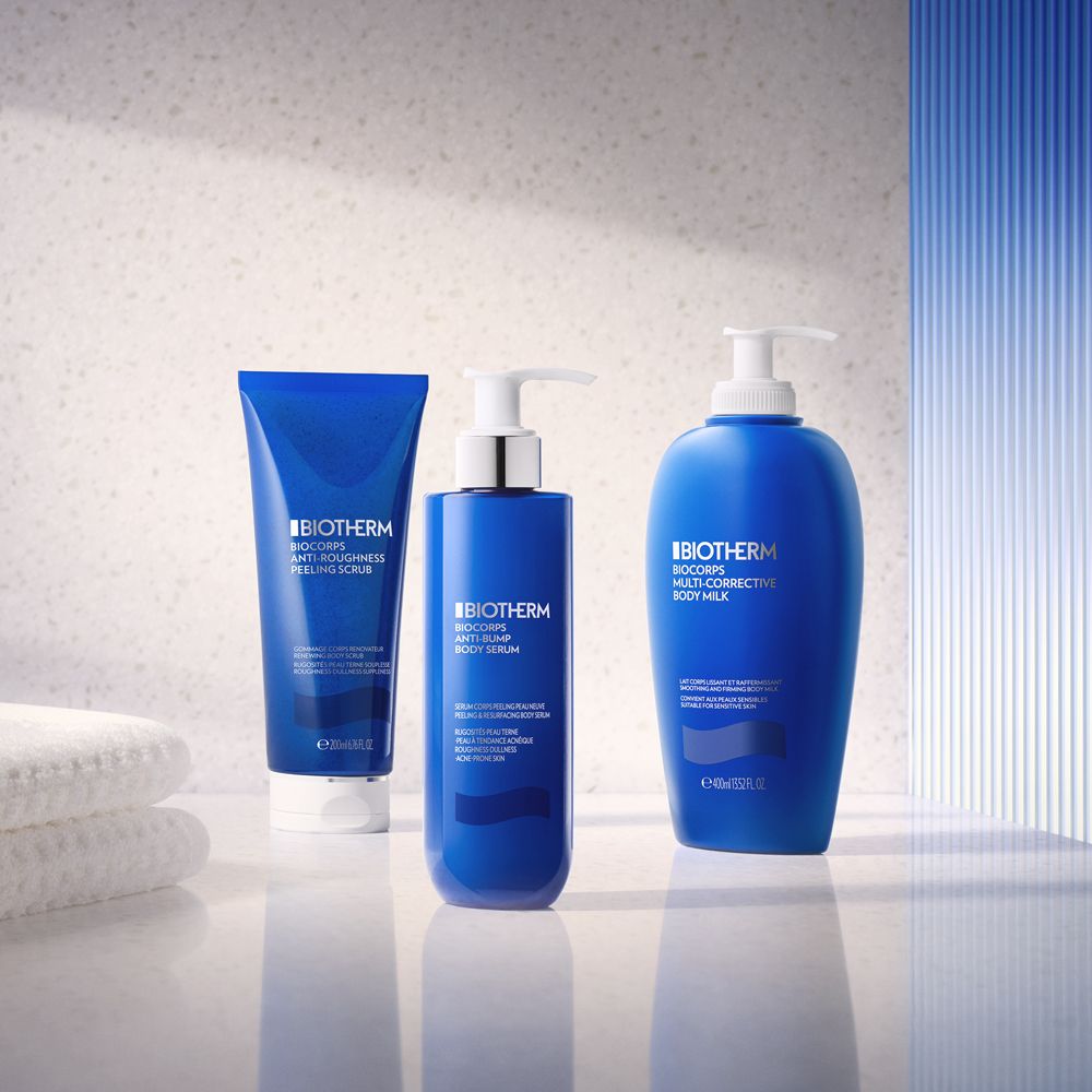 Drei blaue Flaschen. Produkte: Anti-Rauheit Peeling, Body Serum, Body Milk. Aufschrift: Biotherm.