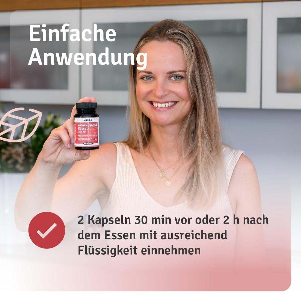 Frau hält Flasche Ashwagandha Kapseln. Text: 2 Kapseln 30 Min. vor oder 2 h nach dem Essen mit ausreichend Flüssigkeit einnehmen.