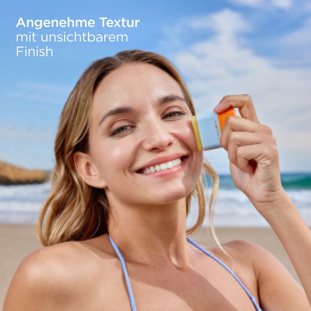 Frau trägt Sonnenstick auf. Text: Angenehme Textur mit unsichtbarem Finish. Produkt mit blauem Deckel und orangefarbener Basis.