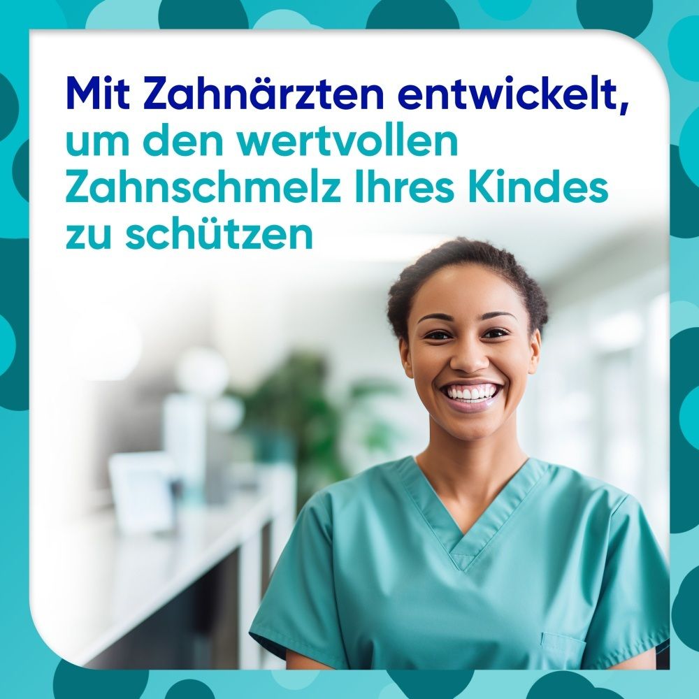 Eine Zahnärztin in grüner Kleidung lächelt.