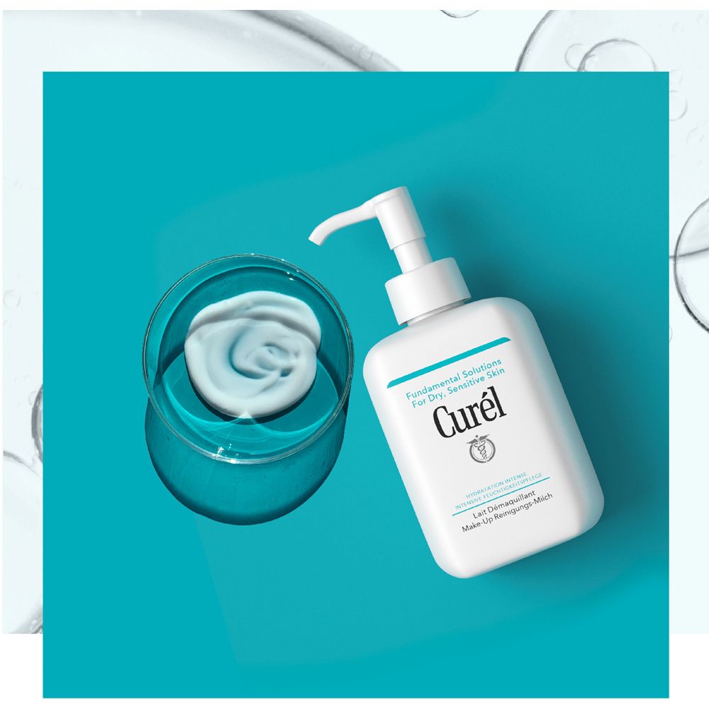 Weißer Spender mit Pumpe und Produkt auf blauem Untergrund. Produkt in einer Schale.