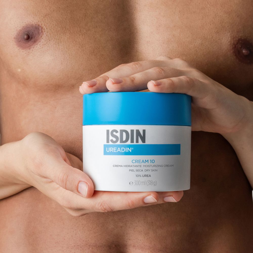 Hände halten eine Creme-Dose mit blauem Deckel. Aufschrift: ISDIN UREADIN CREAM 10.