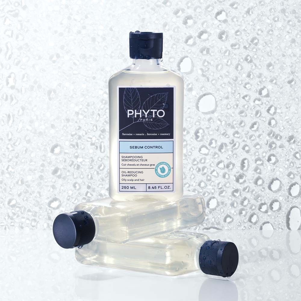 Drei Flaschen mit blauem Deckel. Etikett mit Logo und Text: PHYTO PARIS, Sebum Control, Oil-Reducing Shampoo. Wasserhintergrund.