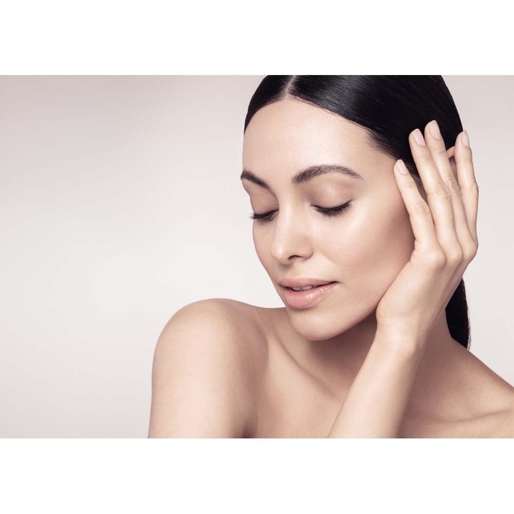 Nahaufnahme einer Frau mit geschlossenen Augen. Sie berührt sanft ihr Gesicht mit der Hand.