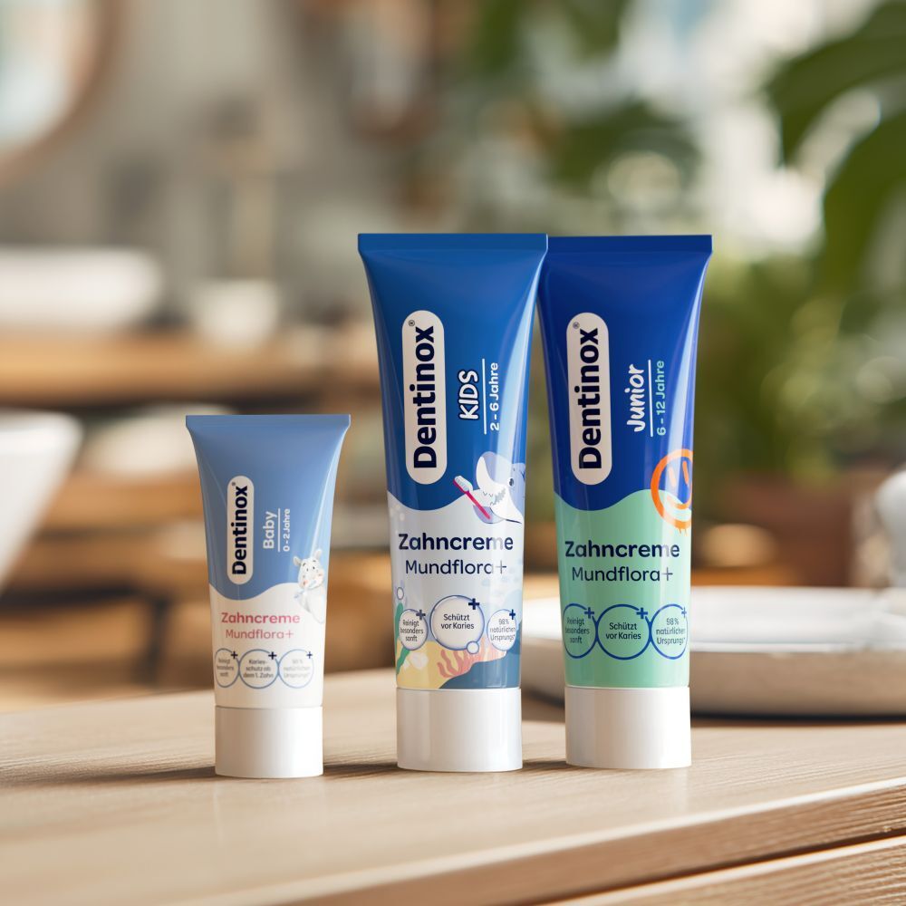 Dentinox Zahncreme-Tuben für Baby, Kids und Junior. Blaue Tuben mit Produktinformationen.