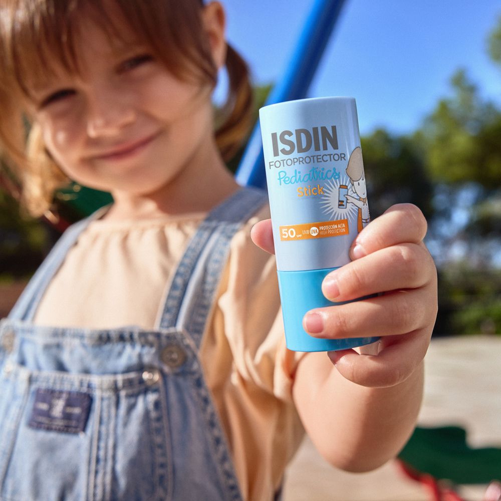 Kind hält blauen Sonnenstick. ISDIN Fotoprotector Pediatrics Stick, LSF 50.