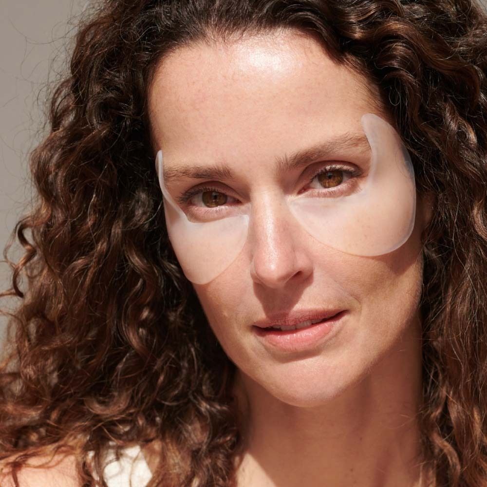 Frau mit APRICOT Eye Temple Pads auf den Augen. Die Pads sind transparent und bedecken die Augenpartie. 