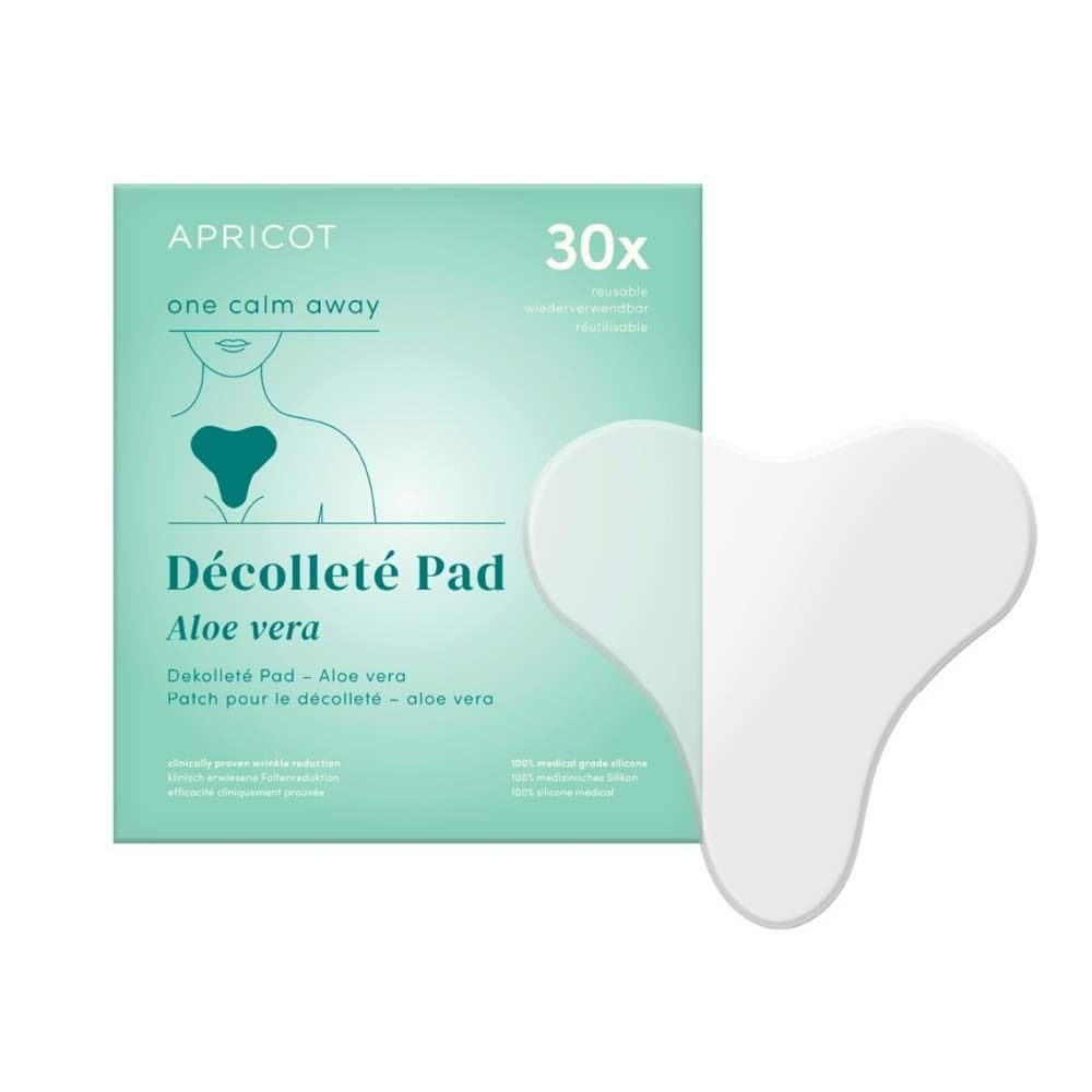 Weißes, herzförmiges Dekolleté Pad neben einer Verpackung. Verpackung mit Produktname, Marke APRICOT und 30 Stück.