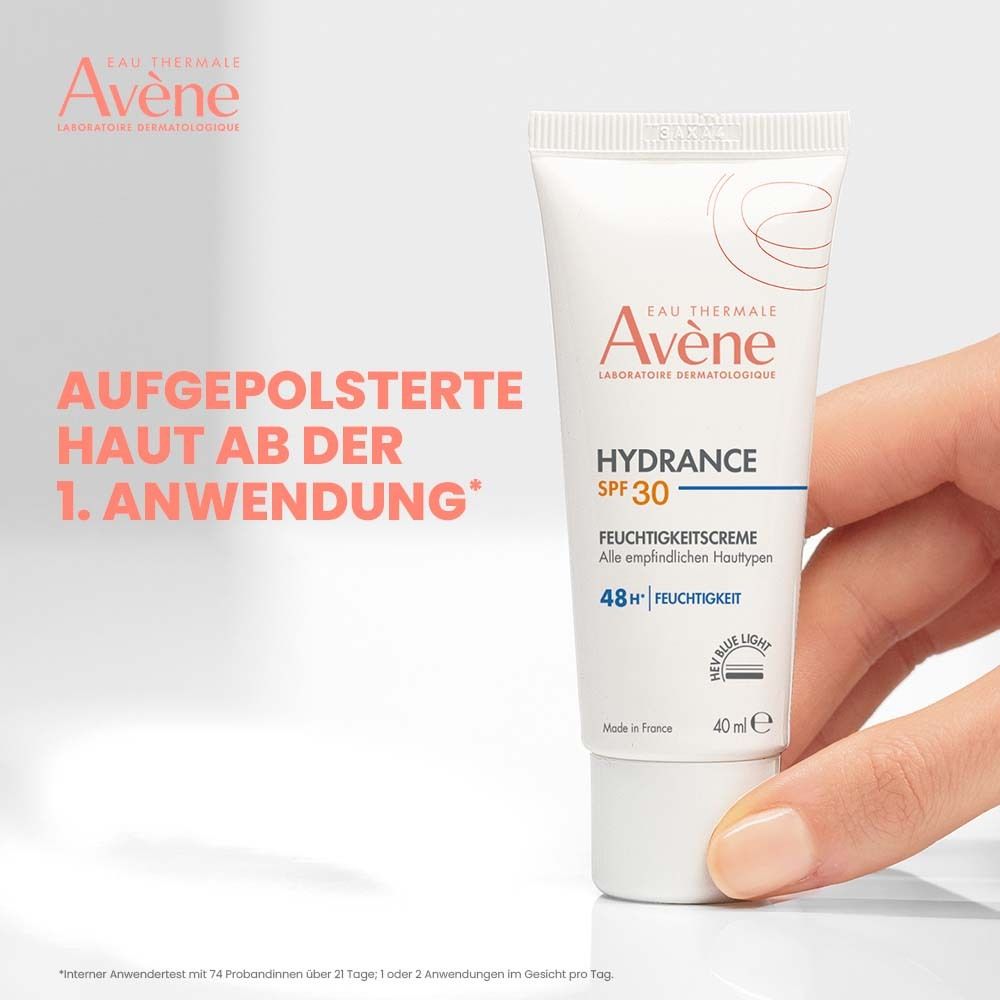 Hand hält Tube Avène Hydrance SPF 30. Text: Aufgepolsterte Haut ab der 1. Anwendung.