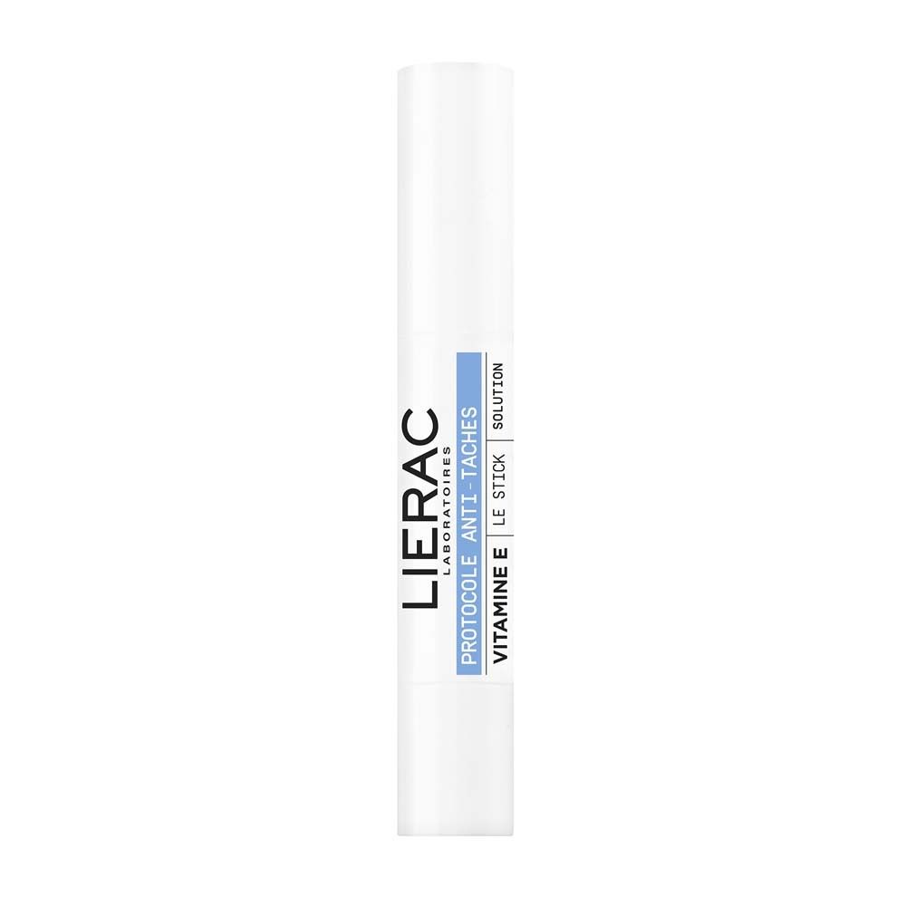 Weißer Stick mit blauer Beschriftung. LIERAC-Logo und Produktinformationen: Protocole Anti-Taches, Vitamin E, Le Stick Solution.