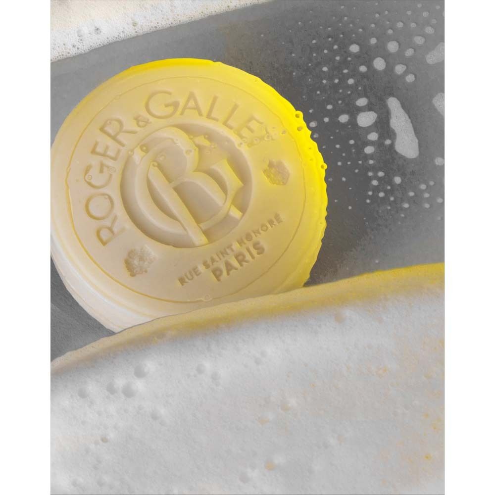 Runde Seife in Seifenschaum. Logo ROGER & GALLET PARIS. Gelbe Beleuchtung.