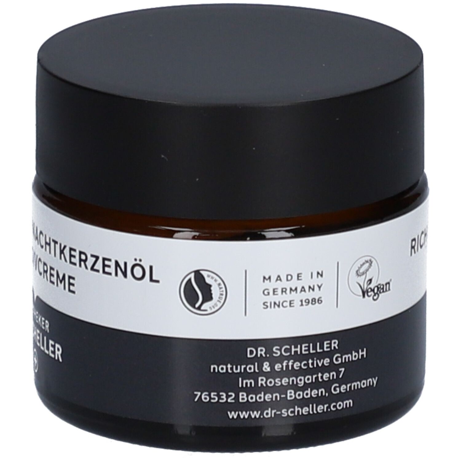 Braunes Creme-Glas mit schwarzem Deckel. Produktname auf weißem Etikett. Vegan-Siegel.