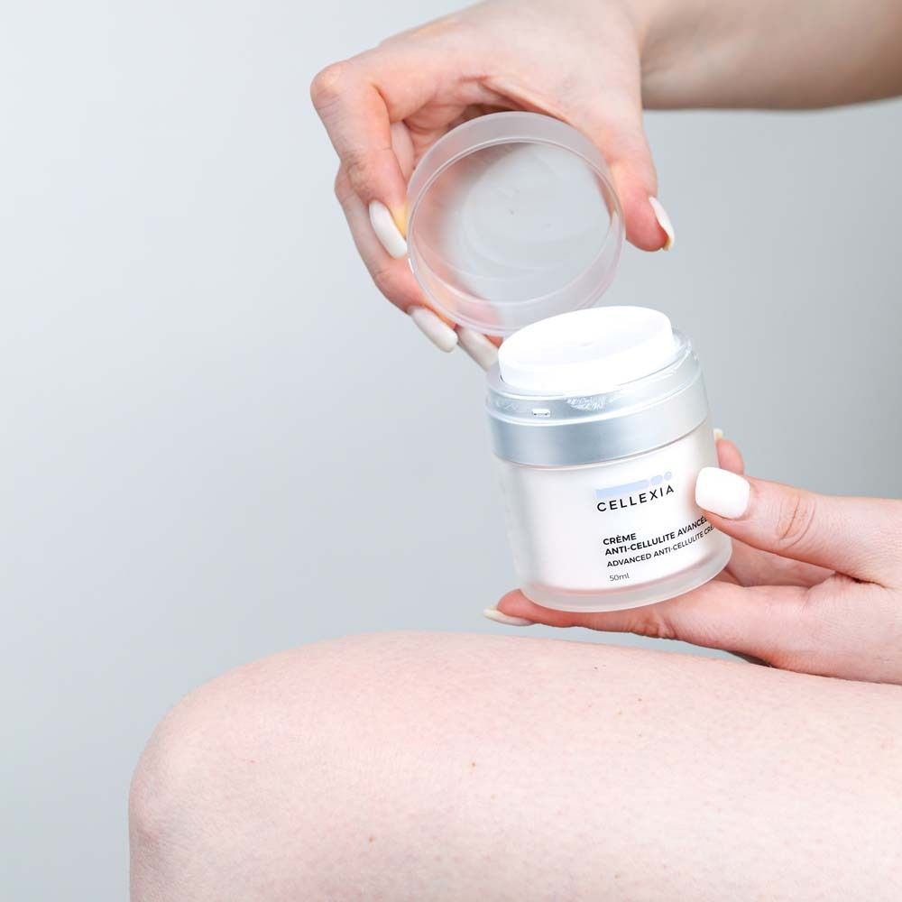 Hände halten Creme-Dose und Deckel. Aufschrift: Cellexia, Crème Anti-Cellulite Avancée, Advanced Anti-Cellulite Cream, 50ml.