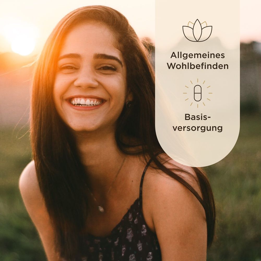 Frau lächelt. Hintergrund: Unschärfe. Text: Allgemeines Wohlbefinden, Basisversorgung. Bild: Lotusblüte und Tablette.