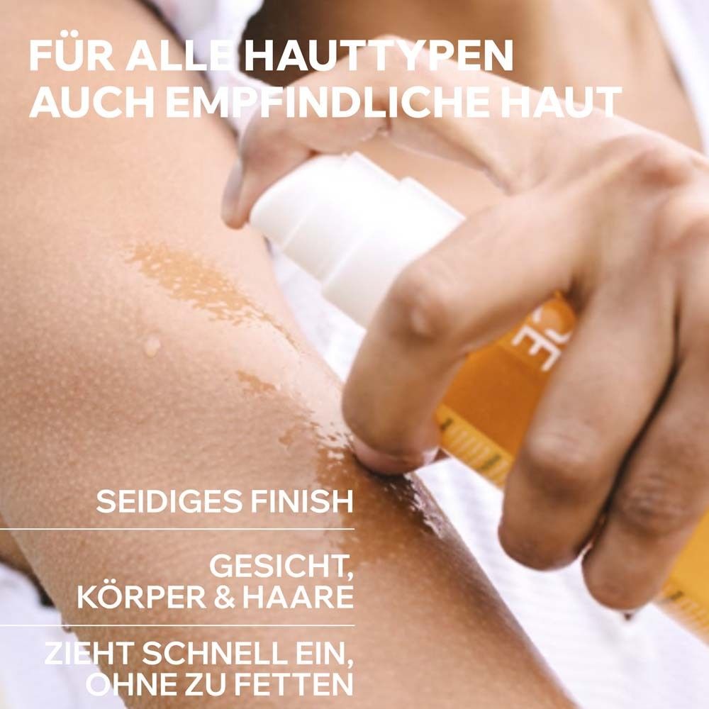 Personne vaporisant l'huile sèche Uriage Bariésun sur le bras. Pour tous types de peau, même sensibles. Fini soyeux.