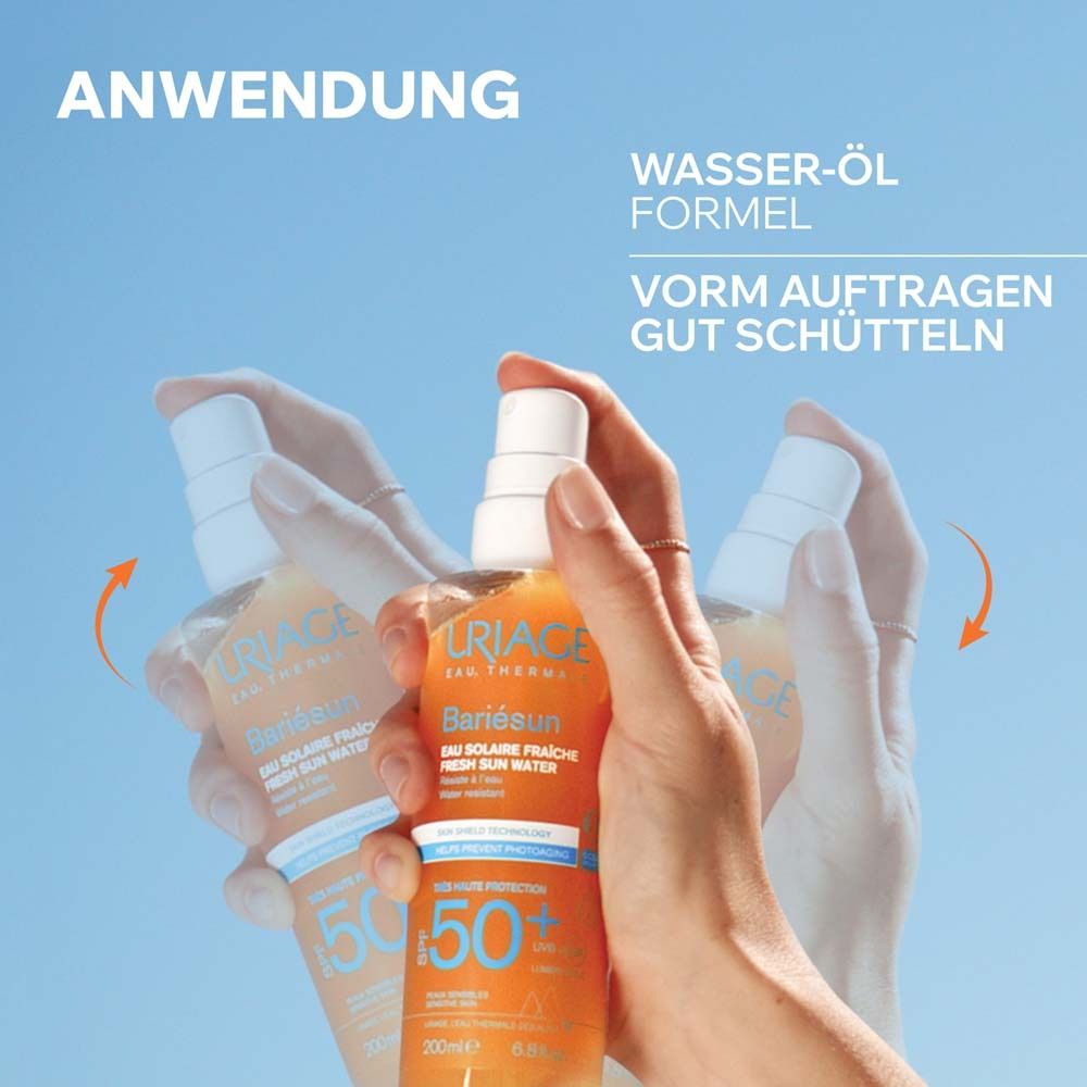 Hände schütteln eine Uriage Bariésun Flasche. Wasser-Öl-Formel. Vor dem Auftragen gut schütteln.