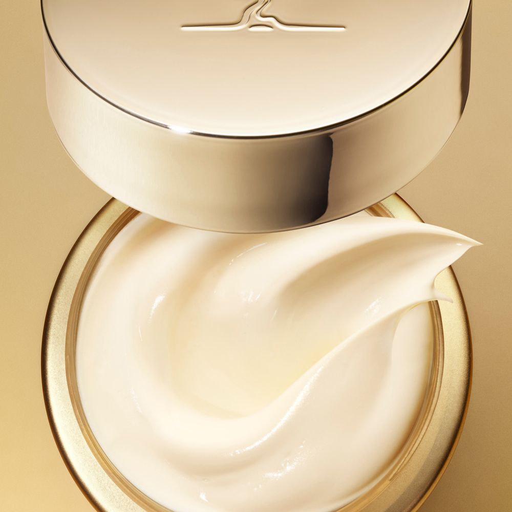 Creme in einem Tiegel. Goldfarbener Deckel. Cremige Textur.
