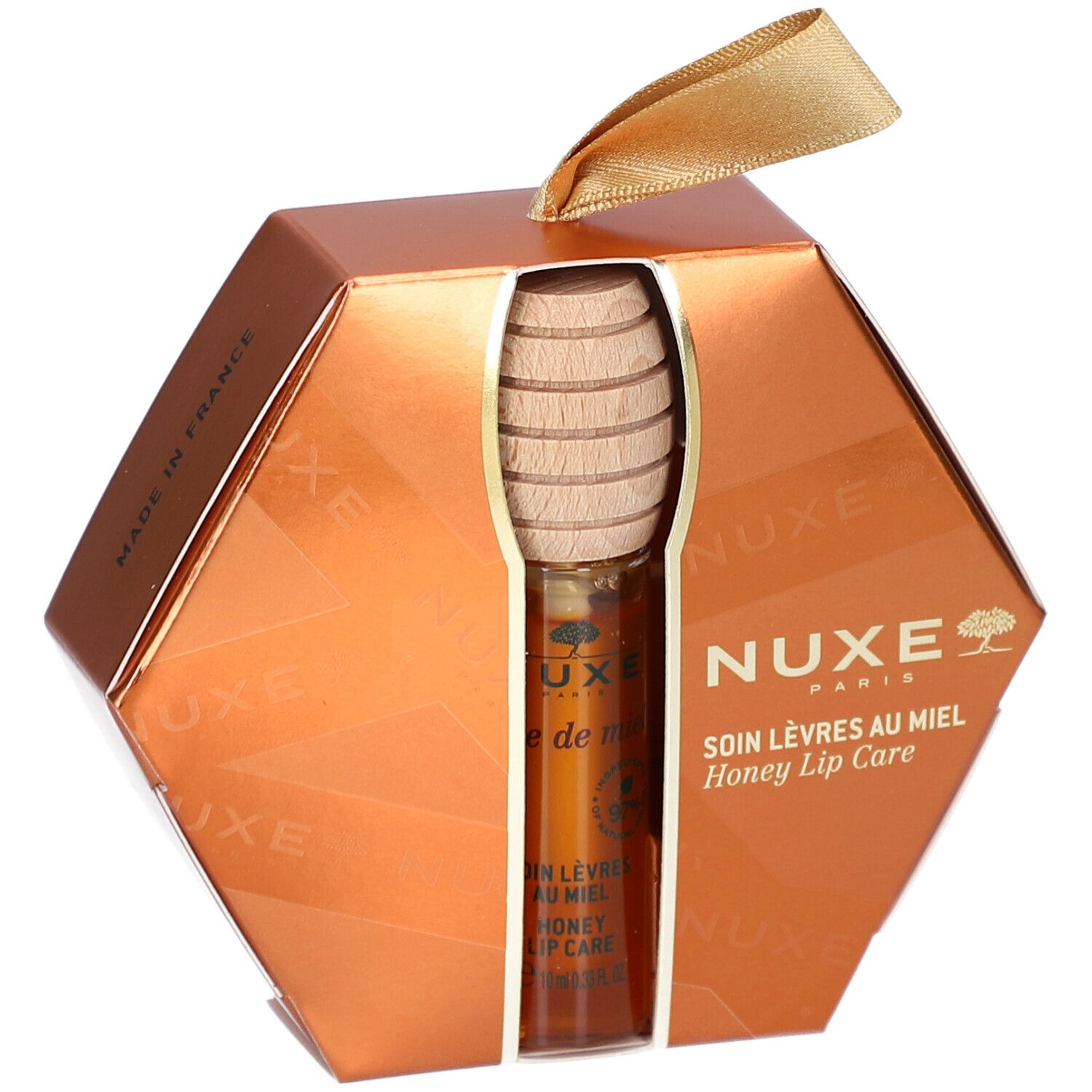 Geschenkset mit Honig-Lippenpflege. Sechseckige, goldfarbene Verpackung. Produkt und Honiglöffel sichtbar. NUXE-Logo.