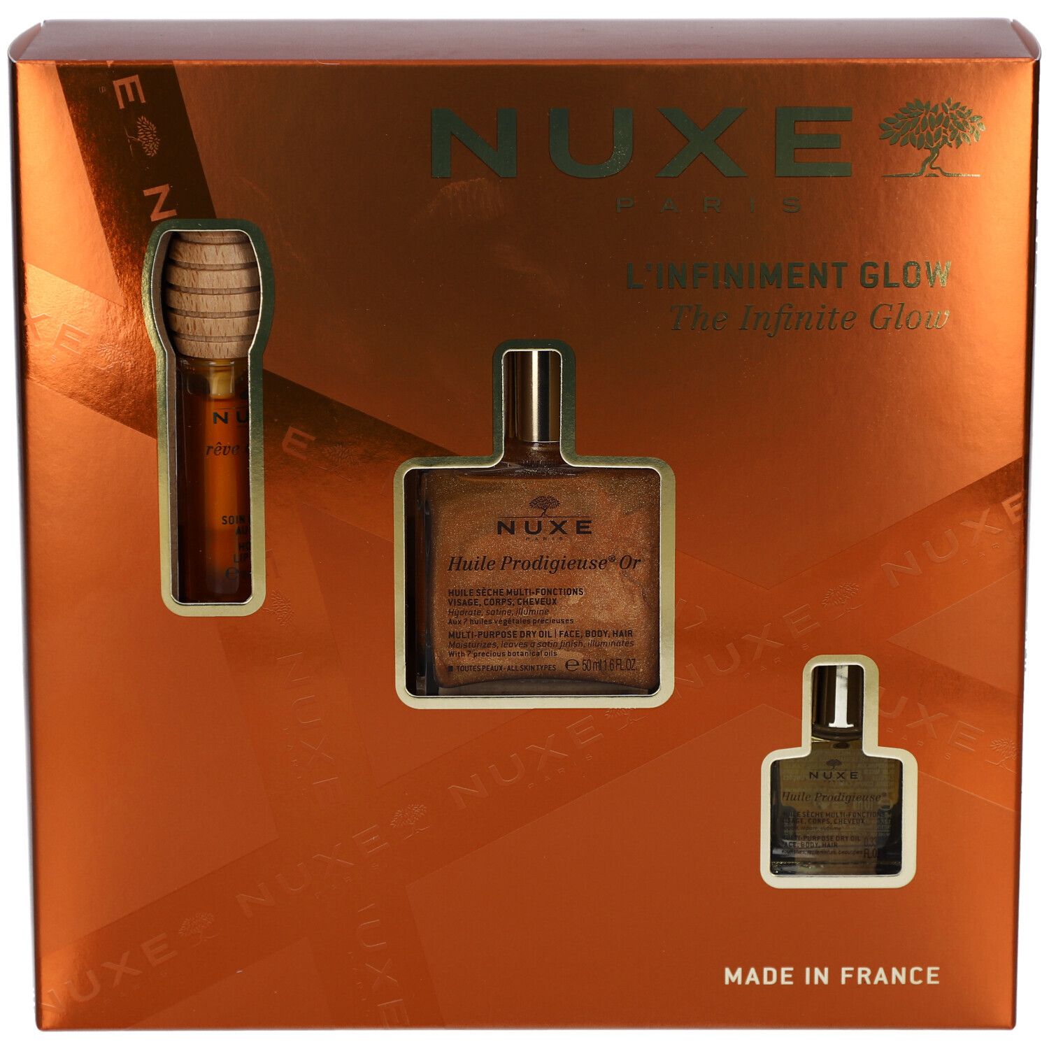 Geschenkbox mit drei Produkten. Sichtbar: NUXE-Logo, Schriftzug "L'Infiniment Glow". Goldfarbene Verpackung.