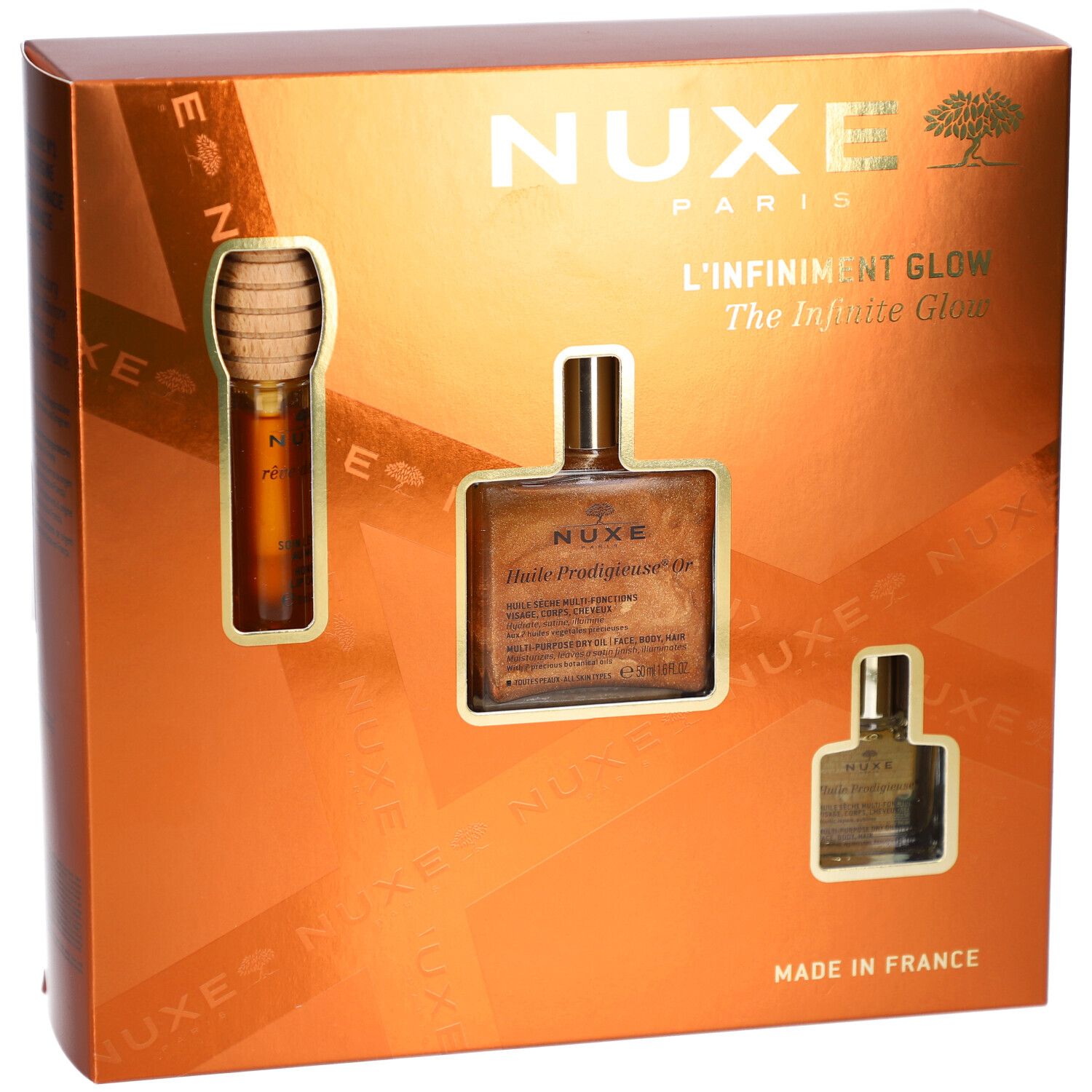 Geschenkbox mit drei Produkten. Sichtbar: NUXE-Logo, Schriftzug "L'Infiniment Glow". Goldfarbene Verpackung.