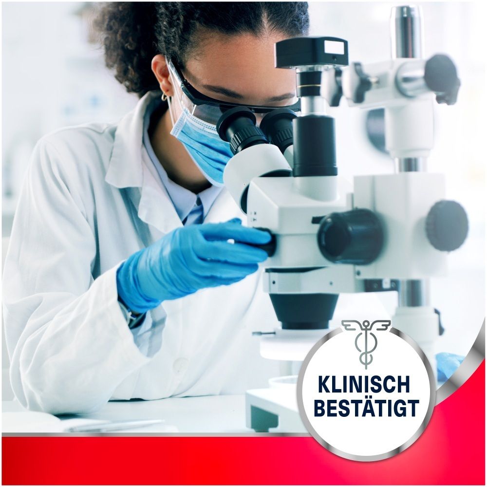 Wissenschaftlerin mit Schutzbrille und Handschuhen am Mikroskop. "Klinisch bestätigt" Siegel.