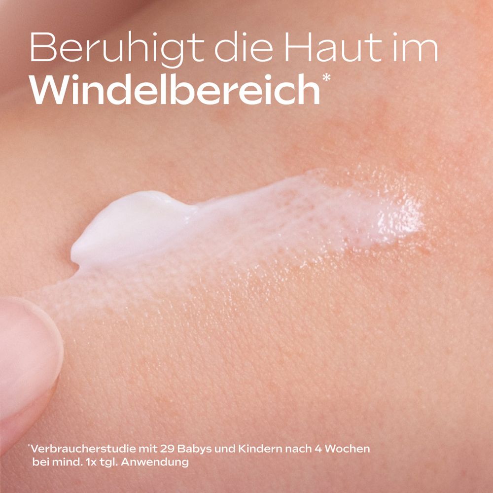 Creme auf Haut aufgetragen, Text: Beruhigt die Haut im Windelbereich.