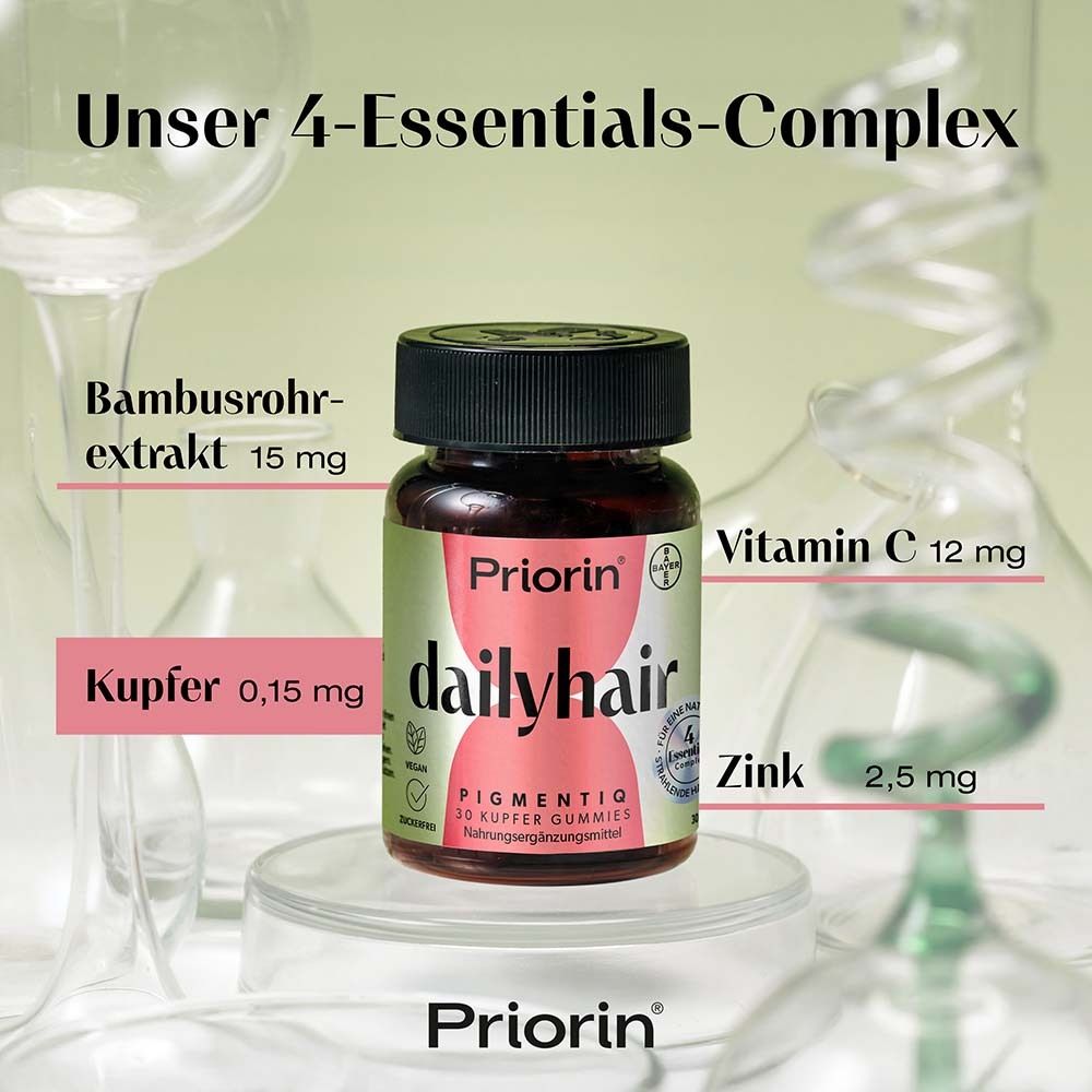 Flasche Priorin dailyhair mit Inhaltsstoffen: Bambus, Kupfer, Vitamin C, Zink. Hintergrund: Laborutensilien.
