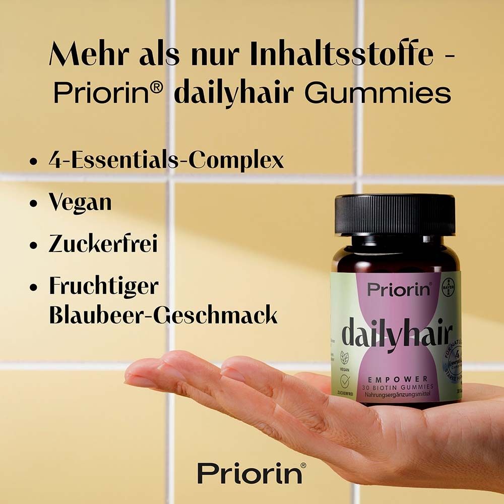 Hand hält Flasche Priorin dailyhair. Text: 4-Essentials-Complex, vegan, zuckerfrei, fruchtiger Blaubeer-Geschmack.