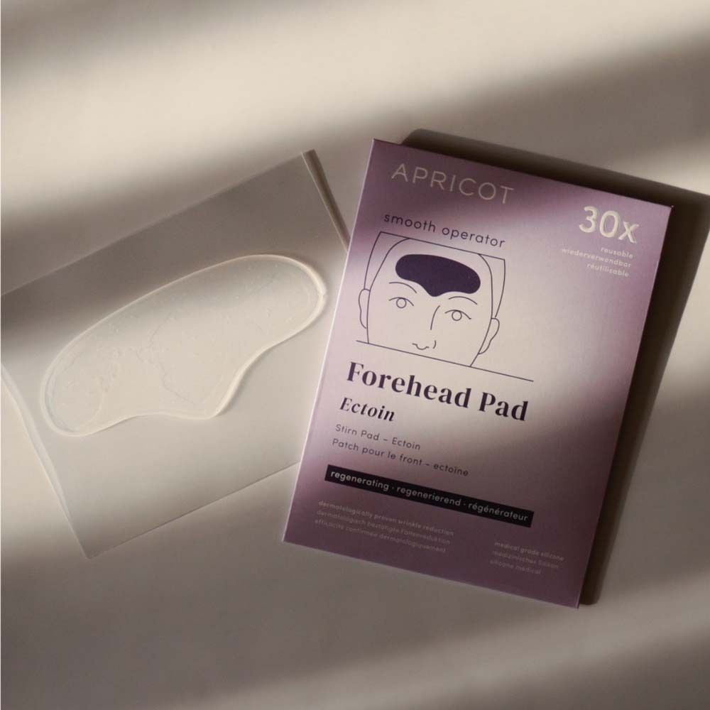 APRICOT Forehead Pad und Verpackung. Pad und Verpackung liegen nebeneinander. Produktname und 30 Stück.