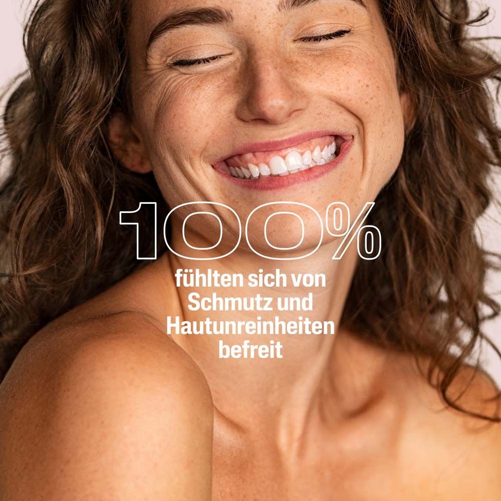 Eine lächelnde Frau. Text: 100% fühlen sich von Schmutz und Hautunreinheiten befreit.