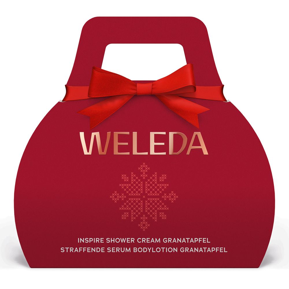 Rote Geschenkbox mit Tragegriff und Schleife. Goldener Schriftzug „WELEDA“ und Produktbezeichnungen. Mit weihnachtlichem Muster.