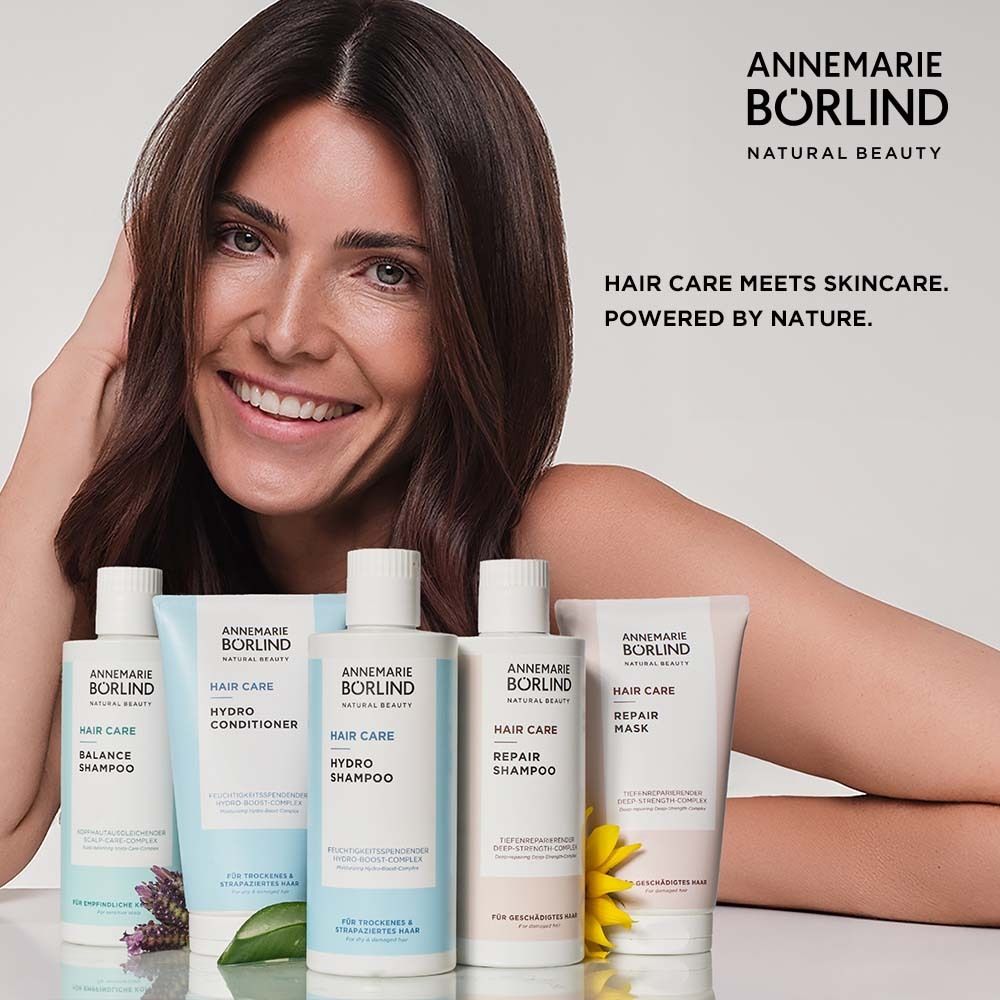 Frau mit Produkten. Produkte: BALANCE SHAMPOO, HYDRO CONDITIONER, HYDRO SHAMPOO, REPAIR SHAMPOO, REPAIR MASK. Text: HAIR CARE meets SKINCARE.