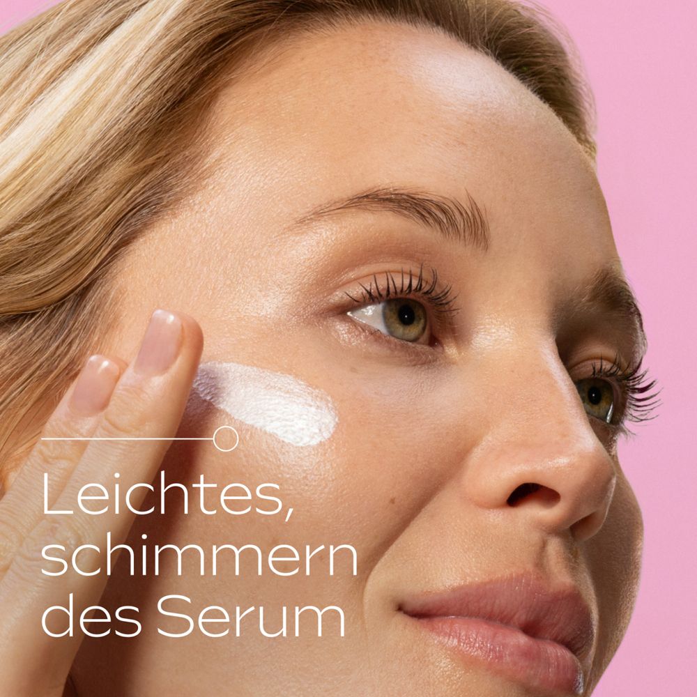 Frau trägt Serum auf. Text: Leichtes, schimmerndes Serum. Rosa Hintergrund.