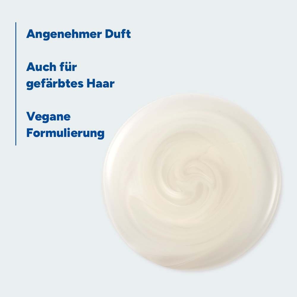 Nahaufnahme einer cremigen Substanz. Text: Angenehmer Duft, Auch für gefärbtes Haar, Vegane Formulierung.