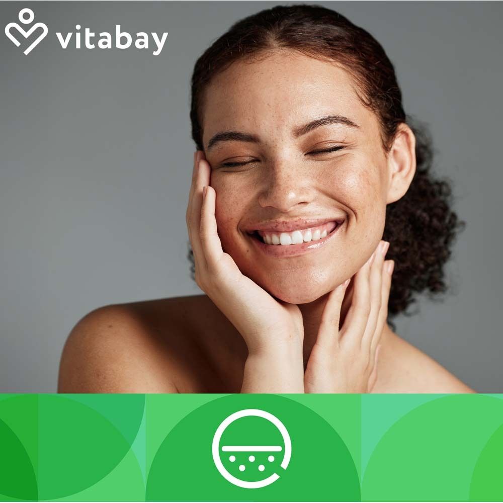 Porträt einer lächelnden Frau, die ihre Haut berührt. Im Hintergrund ein grünes Element mit einem weißen Logo.