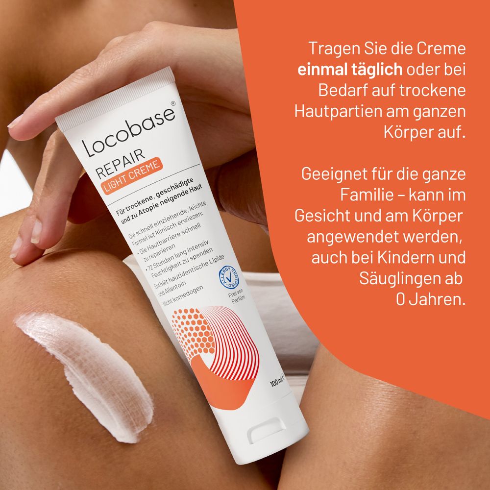 Hand hält eine Tube Locobase Repair Light Creme auf trockener Haut. Creme wird aufgetragen.