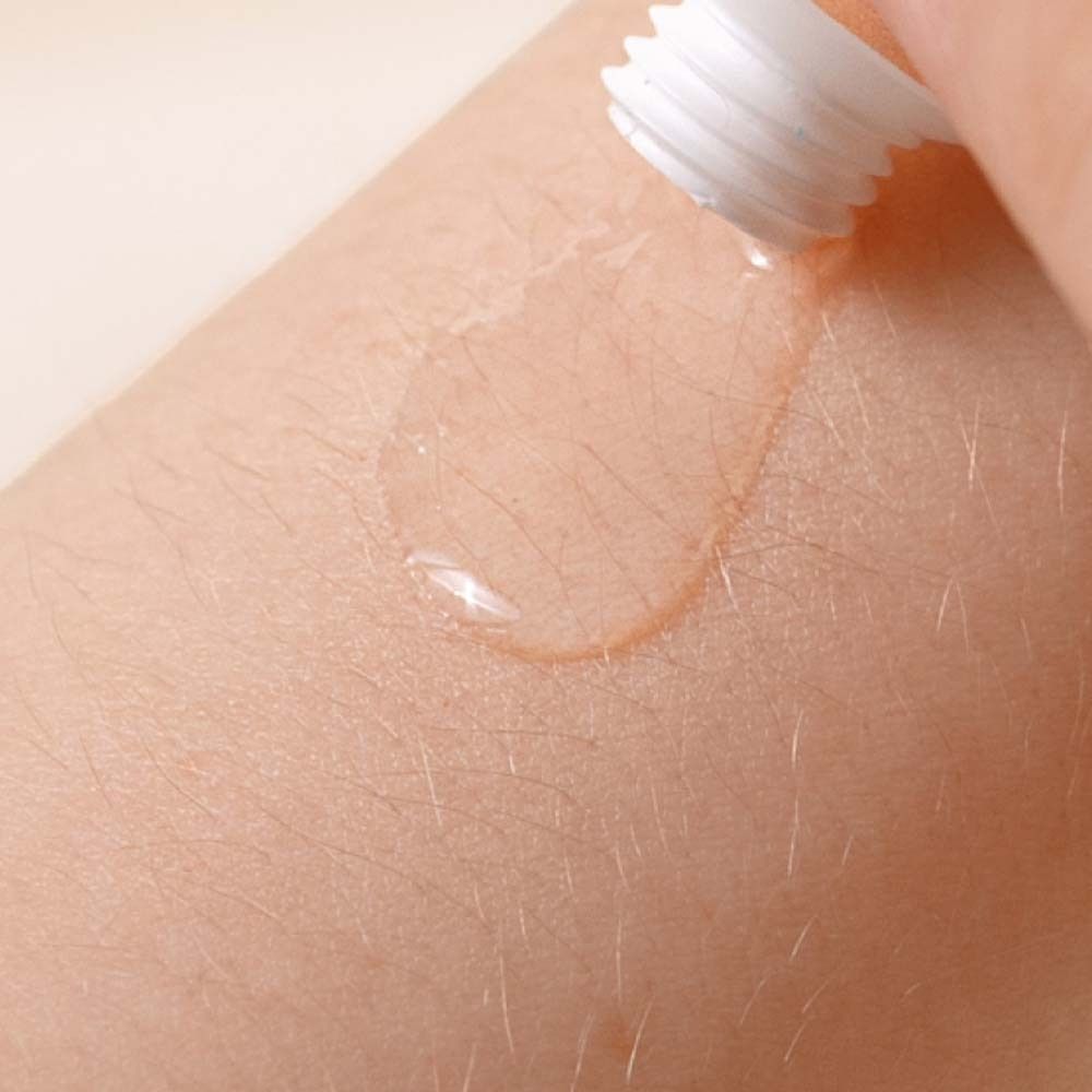 Haut mit transparentem Gel. Gel aus einer Tube aufgetragen.