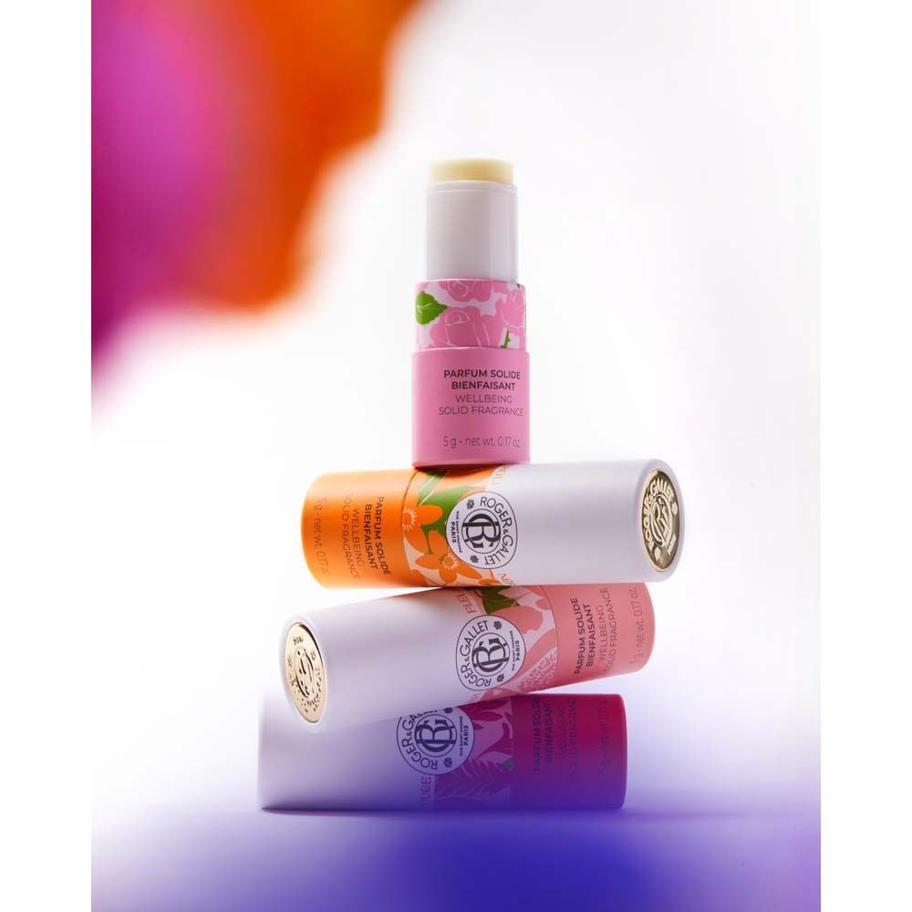 Mehrere Parfumsticks gestapelt. Weiß, orange und rosa. Text: PARFUM SOLIDE BIENFAISANT, ROGER & GALLET.