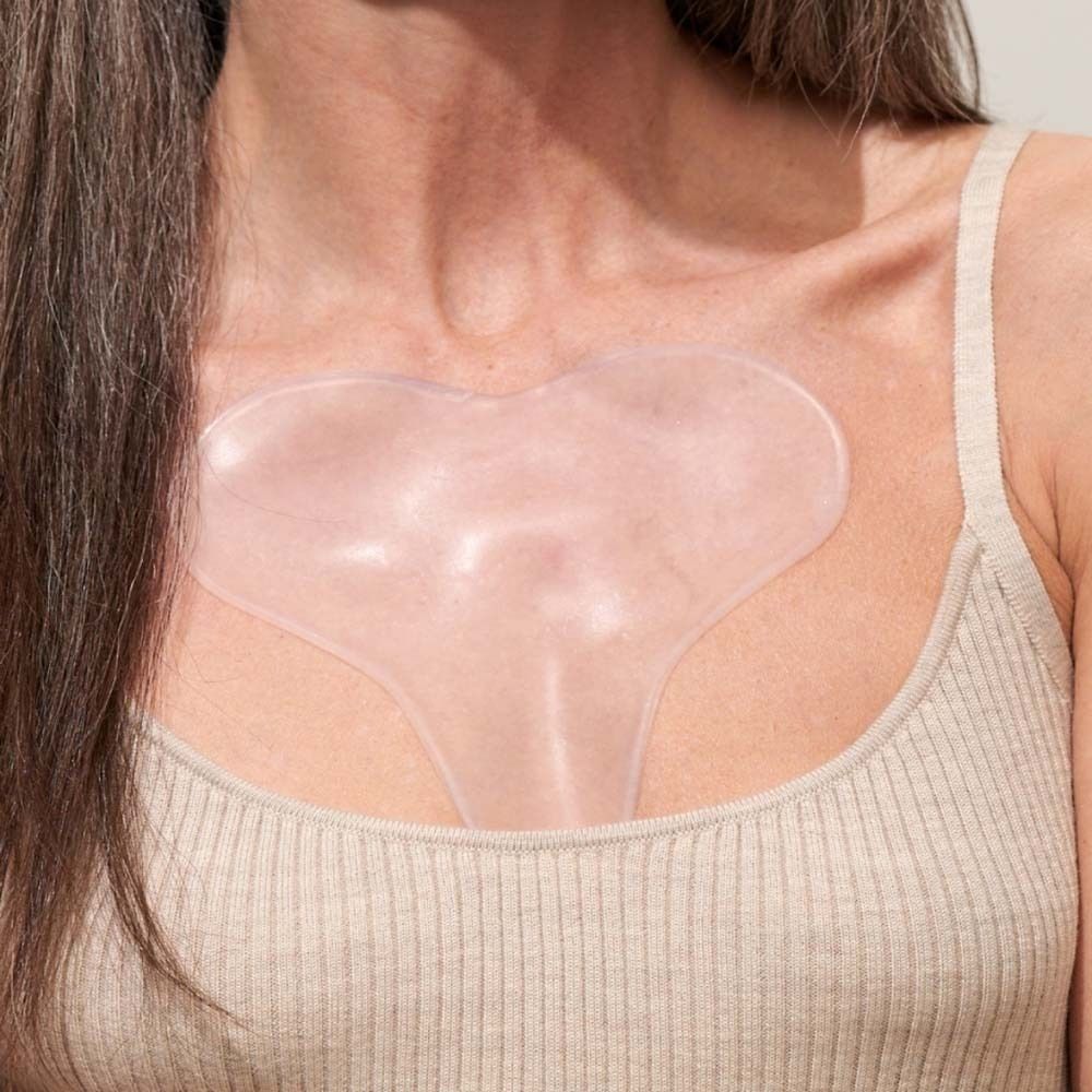 Dekolleté Pad auf dem Dekolleté einer Frau. Transparentes, herzförmiges Pad.