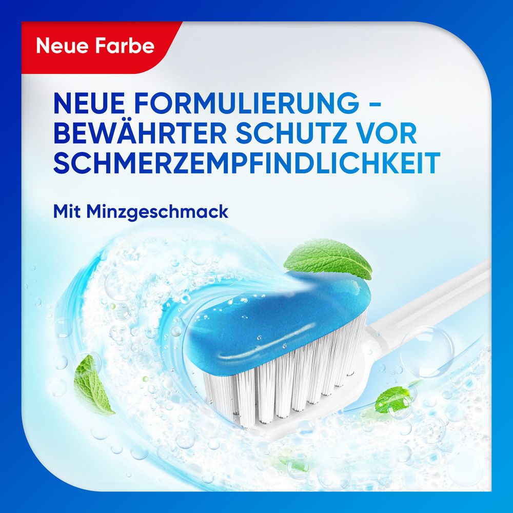 Zahnbürste mit blauem Zahnpasta-Gel und Minzblättern. Nahaufnahme. Produktname nicht sichtbar.